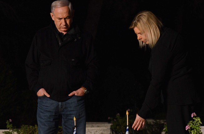 Prime Minister Benjamin Netanyahu and his wife, Sara, seen next to the grave of Netanyahu's late brother Yoni at the Mt Herzl military cemetery in Jerusalem, Saturday, April 13, 2013 (photo credit: Kobi Gideon/Flash90)