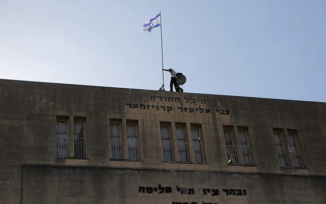 A flag being raised at the Ponovitz Yeshiva in Bnei Brak, which has flown the blue and white every Independence Day since the country's founding. (photo credit: Yaakov Naumi/Flash90)