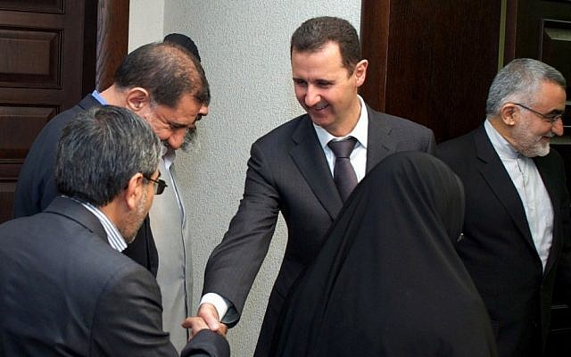 Syrian President Bashar Assad (center), shakes hands with a member of Iran's parliamentary committee on national interest and foreign policy, in Damascus, Syria, April 22, 2013. (photo credit: AP/SANA)