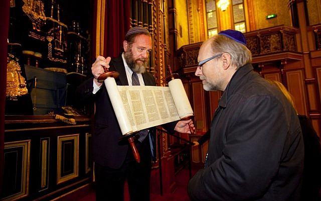 Rabbi David Lazar, left, showing a Torah scroll to Swedish government minister Stefan Attefall at the Great Synagogue of Stockholm, November 2011. (photo credit: Regeringskansliet, The government of Sweden/JTA)