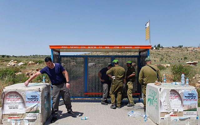 Israeli security forces at a bus stop at the Tapuah Junction inspect the site of a terror attack on April 30, 2013 (photo credit: Flash90)
