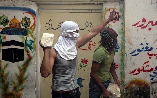 A Palestinian youth prepares to throw a stone at Israeli policemen near Jerusalem's Lion Gate, October 2009 (photo credit: Yossi Zamir/Flash90)