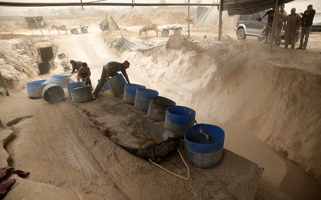 Palestinian workers unload gravel being pulled from a smuggling tunnel between the Hamas-ruled Gaza Strip and Egypt in the southern Gaza Strip city of Rafah on April 3, 2013 (photo credit: Wissam Nassar/Flash90)