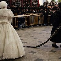 The bride,  Hana Batya Pener, is entreated to a "mitzvah tantz" at her wedding to Rabbi Shalom Rokach, the grandson of the Belz Rabbi, on Tuesday. The dance is a highlight of the wedding ceremony, in which the bride holds one end of a sash while her father and other important men in the community dance on the other end. (Photo credit: Yaakov Naumi/Flash90)