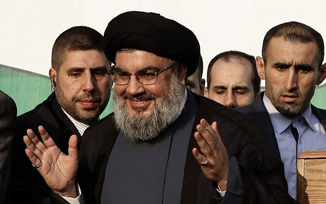 In this Monday, Sept. 17, 2012 file photo, Hezbollah leader Sheik Hassan Nasrallah, center, waves to his supporters, in the southern suburb of Beirut, Lebanon (photo credit: AP/Hussein Malla)