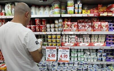 Illustrative: A man looks at dairy products while shopping at a Rami Levy supermarket. (Nati Shohat/Flash90)