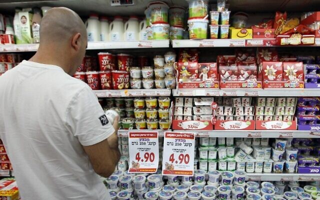 Illustrative: A man looks at dairy products while shopping at a Rami Levy supermarket. (Nati Shohat/Flash90)
