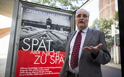 Efraim Zuroff, the top Nazi-hunter of the Simon Wiesenthal Center, talks to journalists as he stands in front of a placard reading 'Operation last chance - late but not too late' displayed in Berlin, Germany, Tuesday, July 23, 2013. (AP Photo/Gero Breloer)