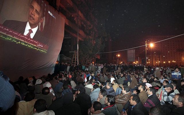 In this Wednesday, Feb. 2, 2011 file photo, anti-government protesters gathered in Cairo's Tahrir Square, watch a screen showing US President Barack Obama live on a TV broadcast from Washington, speaking about the situation in Egypt (photo credit: AP/Lefteris Pitarakis)