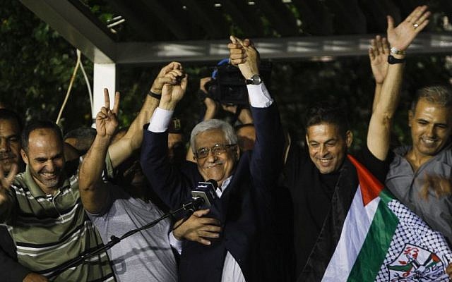 Palestinian Authority President Mahmoud Abbas, center, waves with the released Palestinian prisoners at his headquarters in the West Bank city of Ramallah on August 14 , 2013. (AP Photo/Majdi Mohammed)