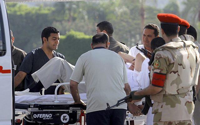 Egyptian medics and military policemen escort former Egyptian president Hosni Mubarak, 85, into an ambulance after he was flown by helicopter to the Maadi Military Hospital in Cairo, Egypt, on Thursday, August 22, 2013. (photo credit: AP/Amr Nabil)