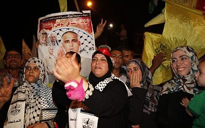 Relatives of Atef Sha’ath, one of the freed Palestinian prisoners, celebrate while waiting for his release at the checkpoint at the entrance of Beit Hanoun in Gaza, Tuesday, Aug. 13, 2013. (photo credit: AP Photo/Adel Hana)