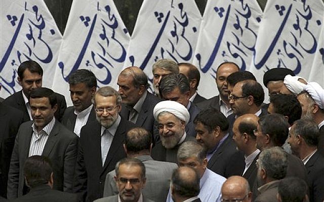 Iranian President-elect Hasan Rouhani (center) arrives for a meeting with lawmakers at parliament, in Tehran, Iran, July 14, 2013 (photo credit: AP Photo/Office of the President-elect, Mohammad Berno)