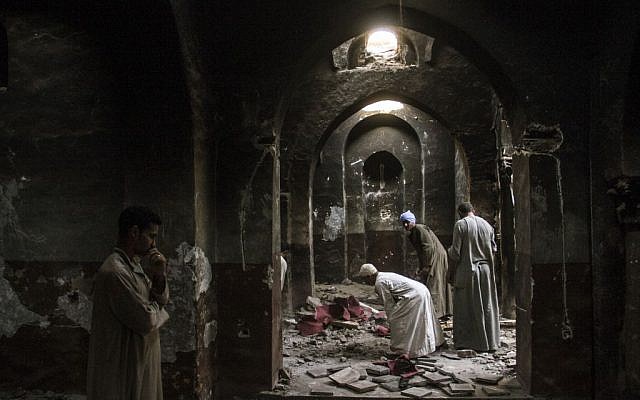 Egyptian Christian villagers clean up the damaged ancient chapel inside the Virgin Mary and St. Abraam Monastery that was looted and burned by Islamists, in Dalga, Minya province, Egypt. (AP Photo/El Shorouk Newspaper, Roger Anis)
