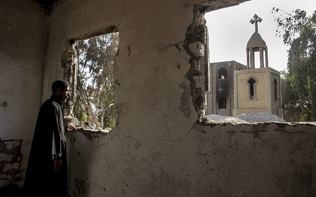 Egyptian priest Samuel Zaki views the damaged main church inside the Virgin Mary and St. Abraam Monastery that was looted and burned by Islamists, in Dalga, Minya province, Egypt. (AP Photo/El Shorouk Newspaper, Roger Anis)