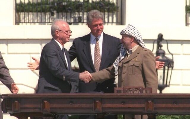 Bill Clinton looks on as Yitzhak Rabin and Yasser Arafat shake hands during the signing of the Oslo Accords, September 13, 1993. On the far right, current Palestinian leader Mahmoud Abbas. (GPO)