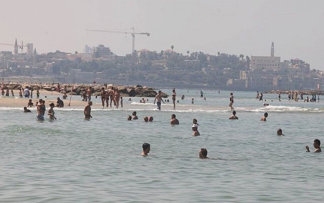 Israelis enjoy a hazy late-summer beach day in Tel Aviv, last week (photo credit: Roni Schutzer/Flash90)