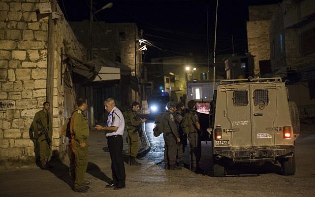 Israeli soldiers stand near the scene of a shooting in the city of Hebron on September 22, 2013 (photo credit: Yonatan Sindel/Flash90)