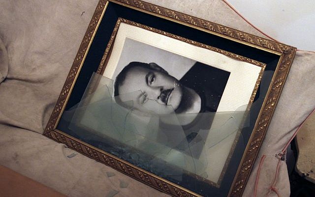 This Sept. 3, 2013, photo, shows a broken picture frame holding an image of the father of Talaat Bassily, a prominent Christian businessman, whose home was looted by criminals in Malawi, Minya province, Egypt. (AP Photo/El Shorouk Newspaper, Roger Anis)