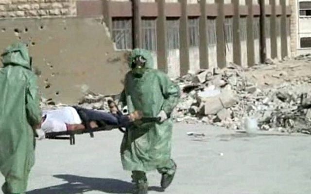 Illustrative photo: This image, from a video posted on September 18, 2013, shows Syrians in protective suits and gas masks conducting a drill on how to treat casualties of a chemical weapons attack, in Aleppo, Syria. (AP)