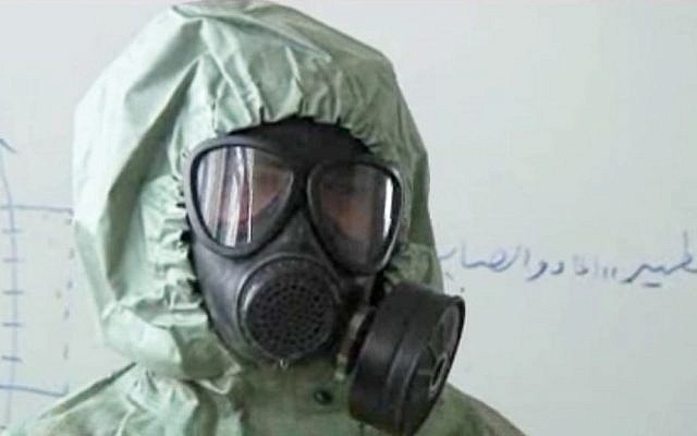 This image made from a video posted on September 18, 2013, shows a student wearing a gas mask and protective suit during a classroom session on how to respond to a chemical weapons attack in Aleppo, Syria (photo credit: AP)
