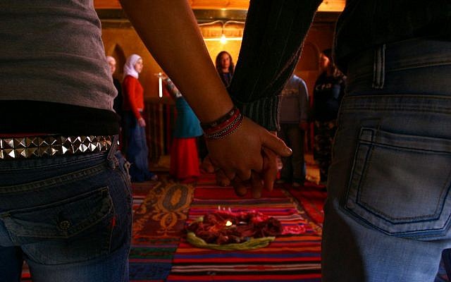 A couple hold hands at a gathering of Jewish and Arab youth. (photo credit: Chen Leopold/Flash90)