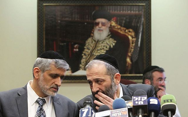 Shas MKs Eli Yishai (left) and Aryeh Deri speak during a Shas party meeting, February 18, 2013 (photo credit: Miriam Alster/Flash90)