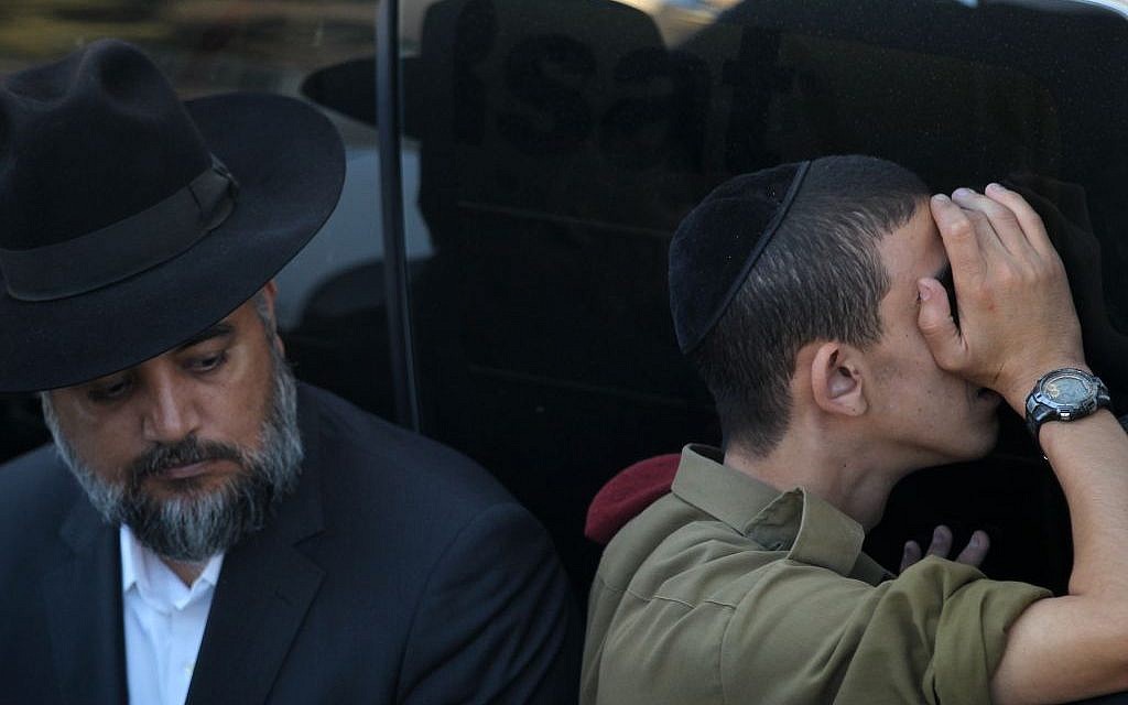 A soldier and an ultra-Orthodox man at the funeral of Rabbi Ovadia Yosef in Jerusalem, October 7, 2013 (photo credit: Nati Shohat/Flash90)
