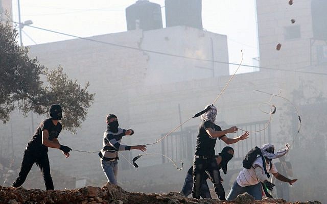 Illustrative photo: Palestinians throwing rocks near Ramallah. (Issam Rimawi/Flash90)