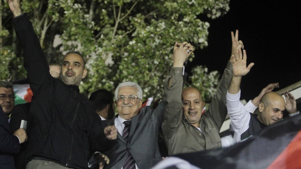 Palestinian Authority President Mahmoud Abbas, flanked by newly released Palestinian prisoners, greets the crowd in Ramallah, on October 30, 2013 (photo credit: Issam Rimawi/Flash90)