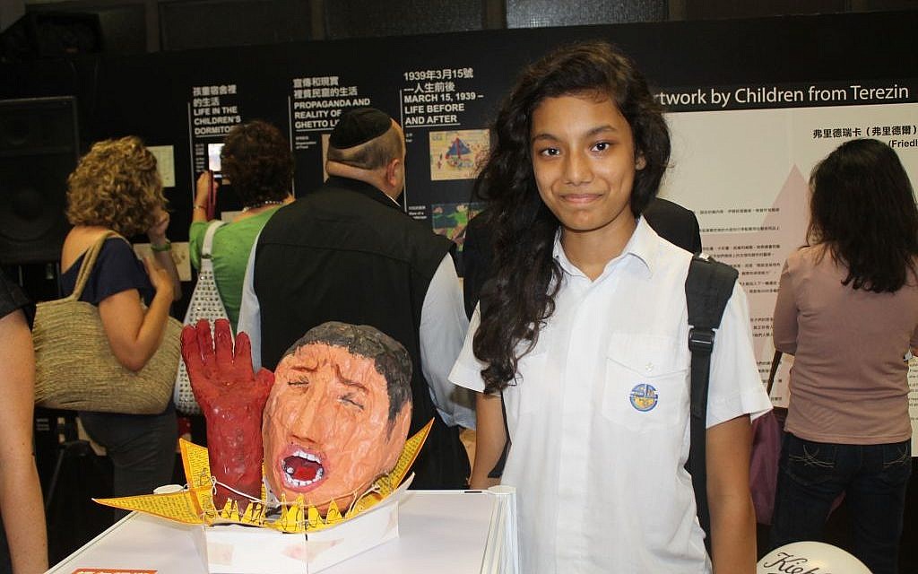 A student with her art at the 'Oasis of Survival and Hope' exhibit in Hong Kong. (photo credit: Erica Lyons)