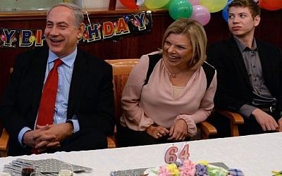 Prime Minister Benjamin Netanyahu sits with his wife Sara and son Yair at his 64th birthday party at the Prime Minister's Office. (photo credit: Kobi Gideon/GPO)