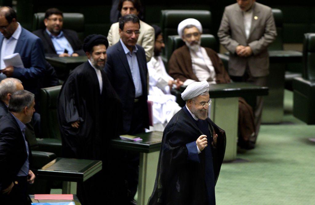 Iranian President Hassan Rouhani, center, leaves at the end of a session of parliament in Tehran, Iran, Sunday, Oct. 27, 2013. (photo credit: AP)
