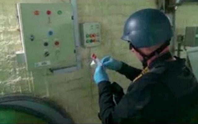 Video broadcast on Syrian State Television purports to show an UN expert examining a chemical weapons plant at an unknown location in Syria, October 8, 2013 (AP/Syrian State Television)