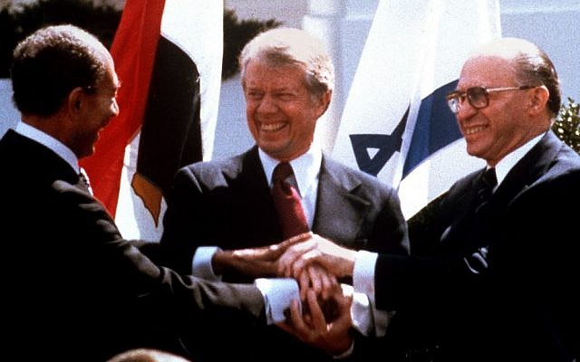 Egyptian President Anwar Sadat, left, US President Jimmy Carter, center, and Prime Minister Menachem Begin clasp hands on the North Lawn of the White House after signing the peace treaty between Egypt and Israel, March 26, 1979 (photo credit: AP/Bob Daugherty/File)
