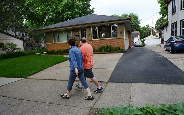 People walk past the home of 94-year-old Michael Karkoc in Minneapolis, June 14, 2013. (AP Photo/The Star Tribune, Richard Sennott)