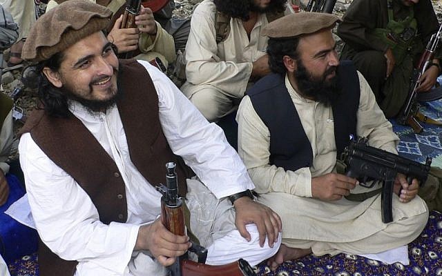 In this file photo taken Sunday, Oct. 4, 2009, Pakistani Taliban chief Hakimullah Mehsud, left, is seen with his comrade Waliur Rehman, front center, during his meeting with media in Sararogha of Pakistani tribal area of South Waziristan along the Afghanistan border. (Photo credit: AP/Ishtiaq Mehsud, File)