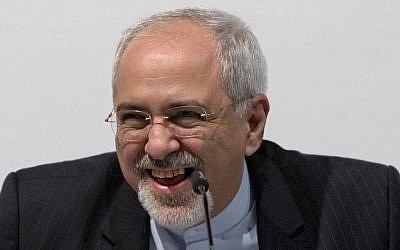 Iranian Foreign Minister Mohammad Javad Zarif smiles and laughs as he speaks to the media at the International Conference Centre of Geneva, Sunday, Nov. 24, 2013, after the interim deal was concluded. (photo credit: AP Photo/Carolyn Kaster, Pool)