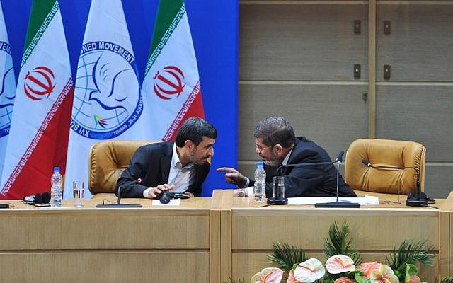 In this photo released by Iranian Students News Agency, ISNA, Iranian President Mahmoud Ahmadinejad, left, speaks to Egyptian President Mohammed Morsi during the summit of the Nonaligned Movement in Tehran, Iran, Thursday, Aug. 30, 2012 (photo credit: AP/Amir Kholousi)