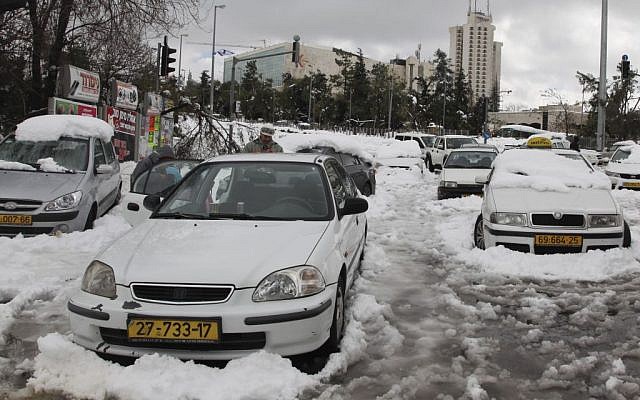 Cars can be seen stuck in the snow at the entrace to Jerusalem after a major snowstorm hits the capital on Friday, December 13, 2013. (photo by Meital Cohen/Flash 90)