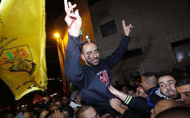 Palestinian prisoner Samer al-Issawi, who held a hunger strike for several months, flashes the 'V' for victory sign as he celebrates his release from an Israeli jail in the Arab Jerusalem neighborhood of Issawiya, on December 23, 2013. (photo credit: Sliman Khader/Flash90)