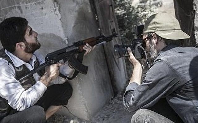 Spanish photographer Ricardo Garcia-Vilanova, right, who was kidnapped in Syria 11 weeks ago takes photographs of a Free Syrian Army fighter in Aleppo, Syria. (AP Photo/Narciso Contreras)