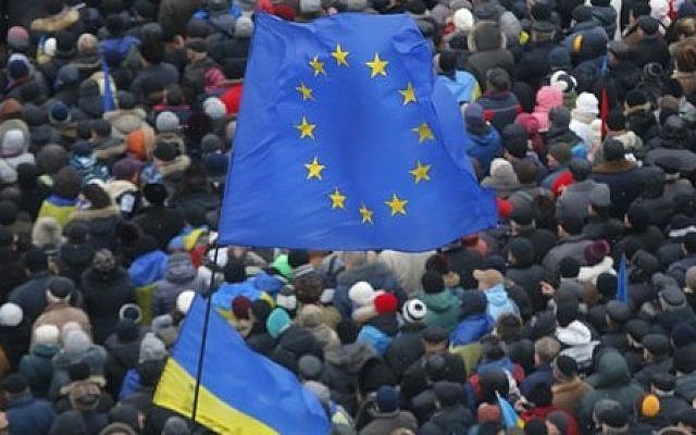 European Union and Ukrainian national flags fly above a crowd of Pro-European Union activists gathered during a rally in Independence Square in Kiev, Ukraine, Sunday, Dec. 8, 2013 (photo credit: AP/Sergei Grits)