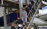 Illustrative: A handcuffed Yitzhak Abergil is led off a plane from the US by police and prison service officials (Israel Prison Service)