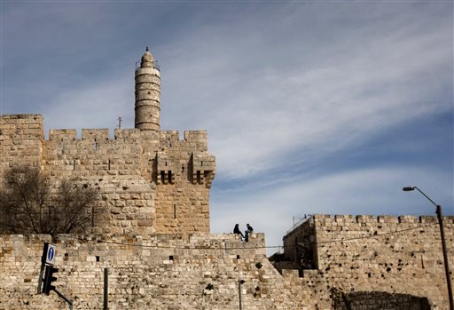 In this March 7, 2012 file photo, a couple sits next to the Tower of David on the wall surrounding Jerusalem's old city. (photo credit: AP/Sebastian Scheiner, File)