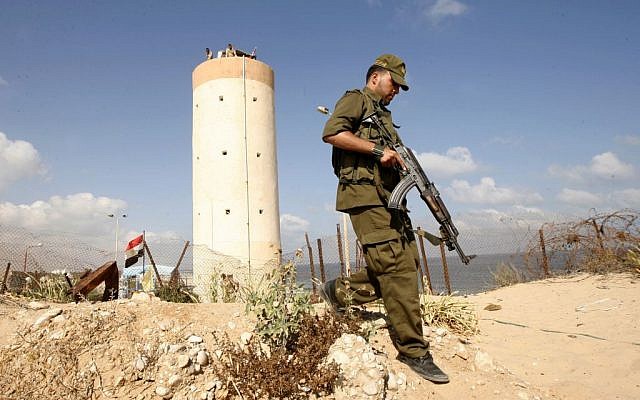Palestinian Hamas security guards walk near an Egyptian watch tower on the border with Egypt in Rafah, southern Gaza Strip, on July 5, 2013 (photo credit: Abed Rahim Khatib/Flash90)