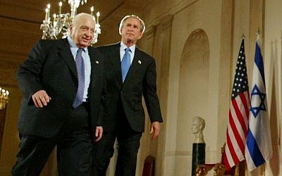 George W. Bush, right, and Ariel Sharon, left, walk together at the end of a joint press conference in the Cross Hall of the White House in Washington in April, 2004. (photo credit: AP/Pablo Martinez Monsivais, File)