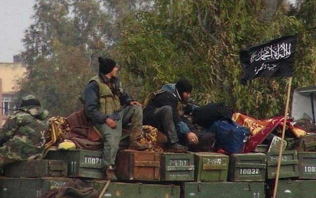 This January 2013 citizen journalism image shows rebels from al-Qaeda affiliated Jabhat al-Nusra, as they sit on a truck full of ammunition, at Taftanaz air base, that was captured by the rebels, in Idlib province, northern Syria. The photo was authenticated based on its contents and other AP reporting. (photo credit: AP Photo/Edlib News Network, ENN, File)