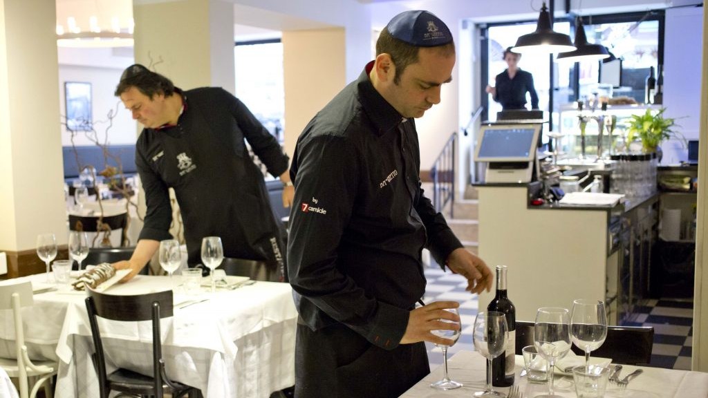 Ba'Ghetto restaurant owners Ilan Dabush, left, and his brother Amit work in their restaurant, which was tapped to cater Pope Francis' luncheon. (photo credit: AP/Alessandra Tarantino)