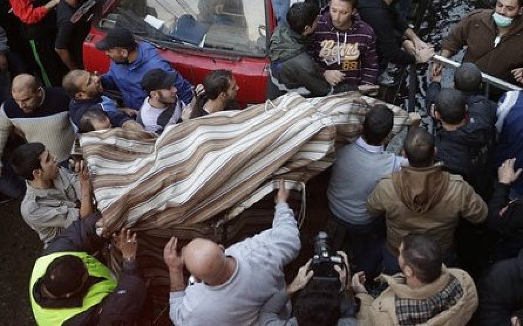 Lebanese citizens carry a covered body from the site of an explosion in a stronghold of the Shiite Hezbollah group at the southern suburb of Beirut, Lebanon, Thursday, Jan. 2, 2014 (photo credit: AP/Hussein Malla)